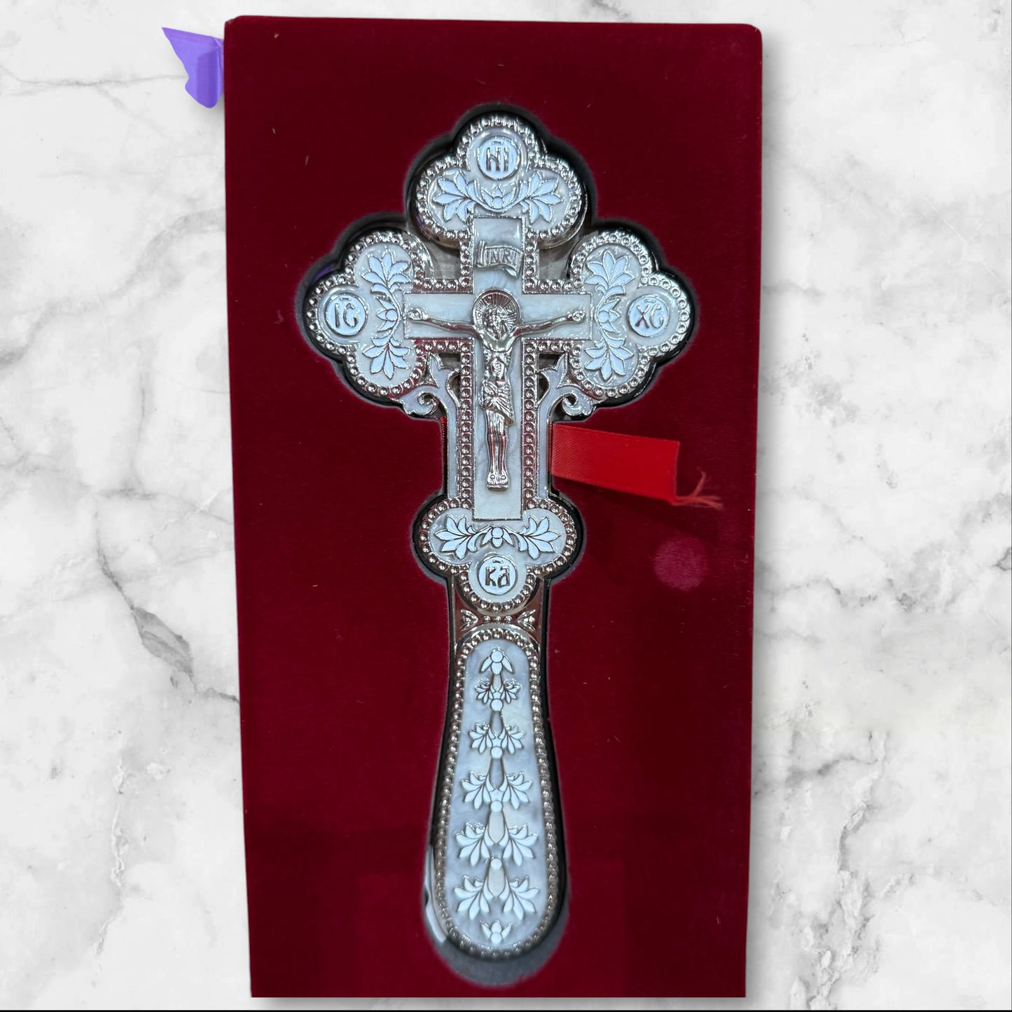 white enamel blessing cross with metal crucifix displayed inside a premium gift box.