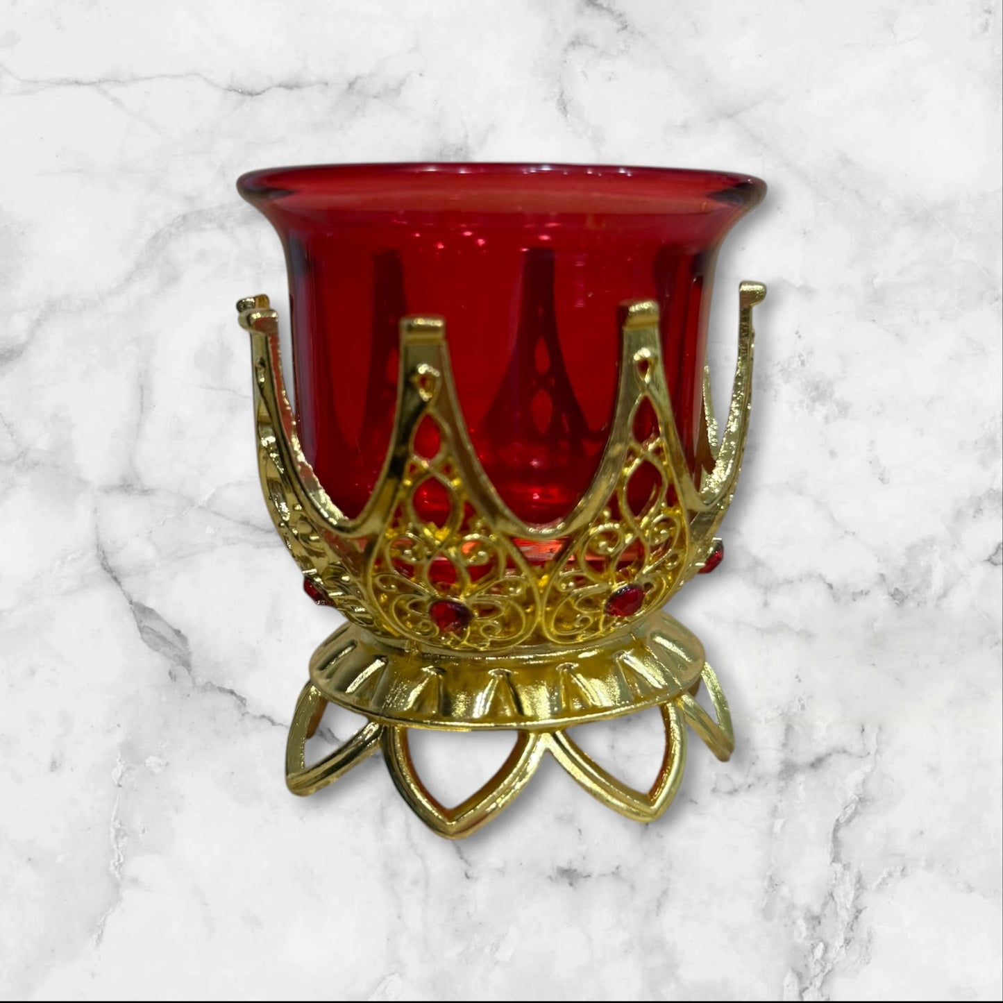 Orthodox ruby red glass votive candle holder with decorative gold-tone filigree base for a home prayer corner.