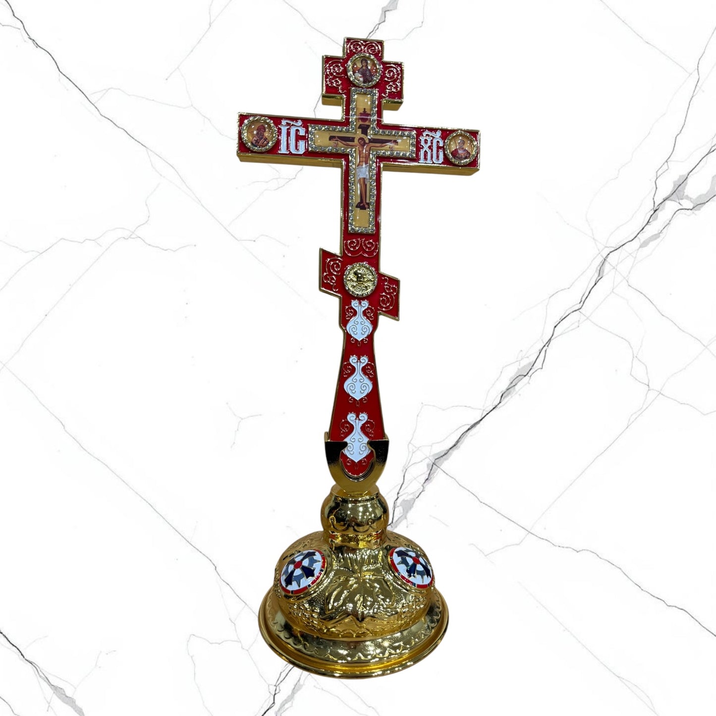 Orthodox standing blessing cross with red enamel accents, central crucifix, icon medallions, and decorative gold-tone base.