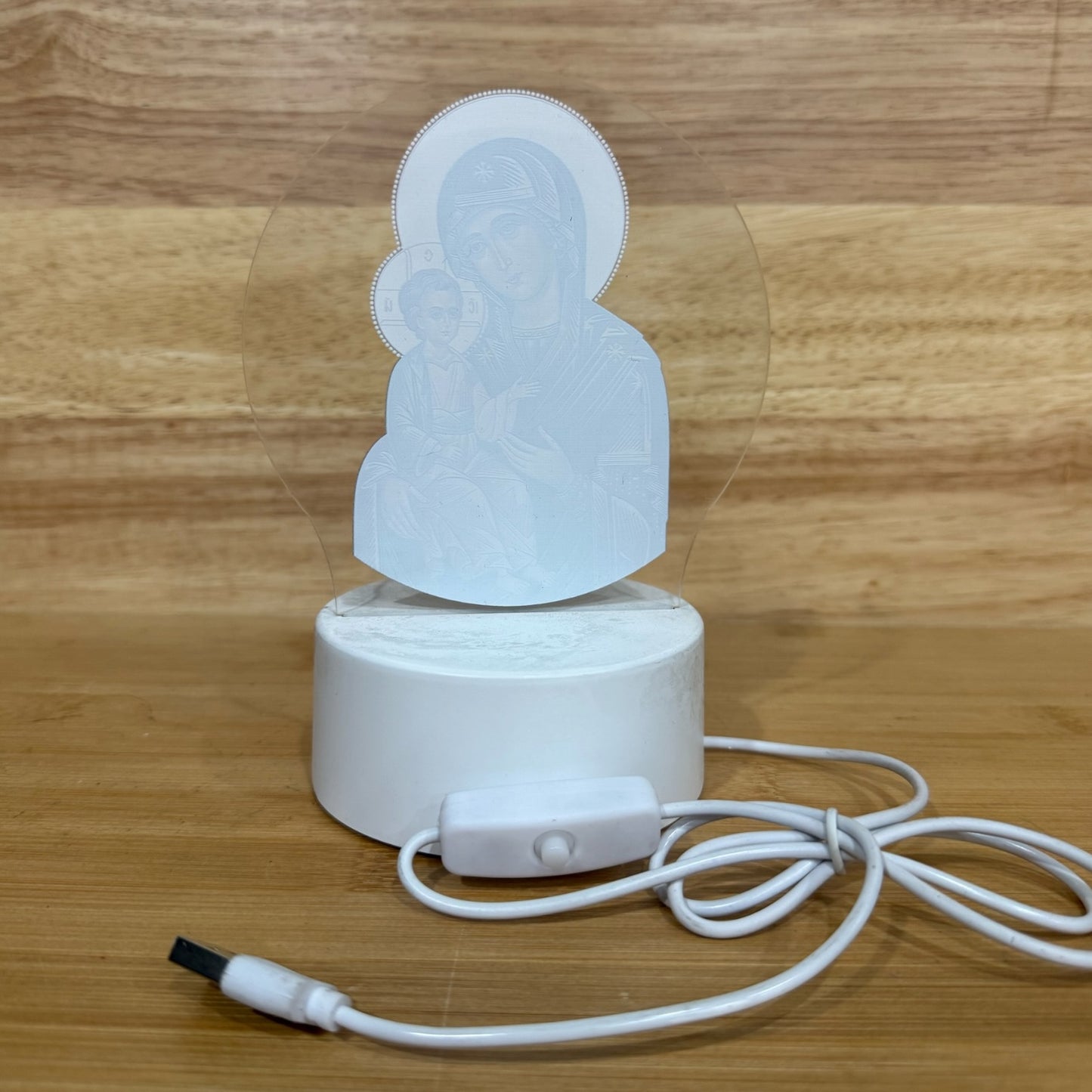 Illuminated acrylic LED night light featuring the Mother of God of Kazan icon on a white USB-powered base. Ideal for an icon corner, bedside table, nursery, or prayer space.