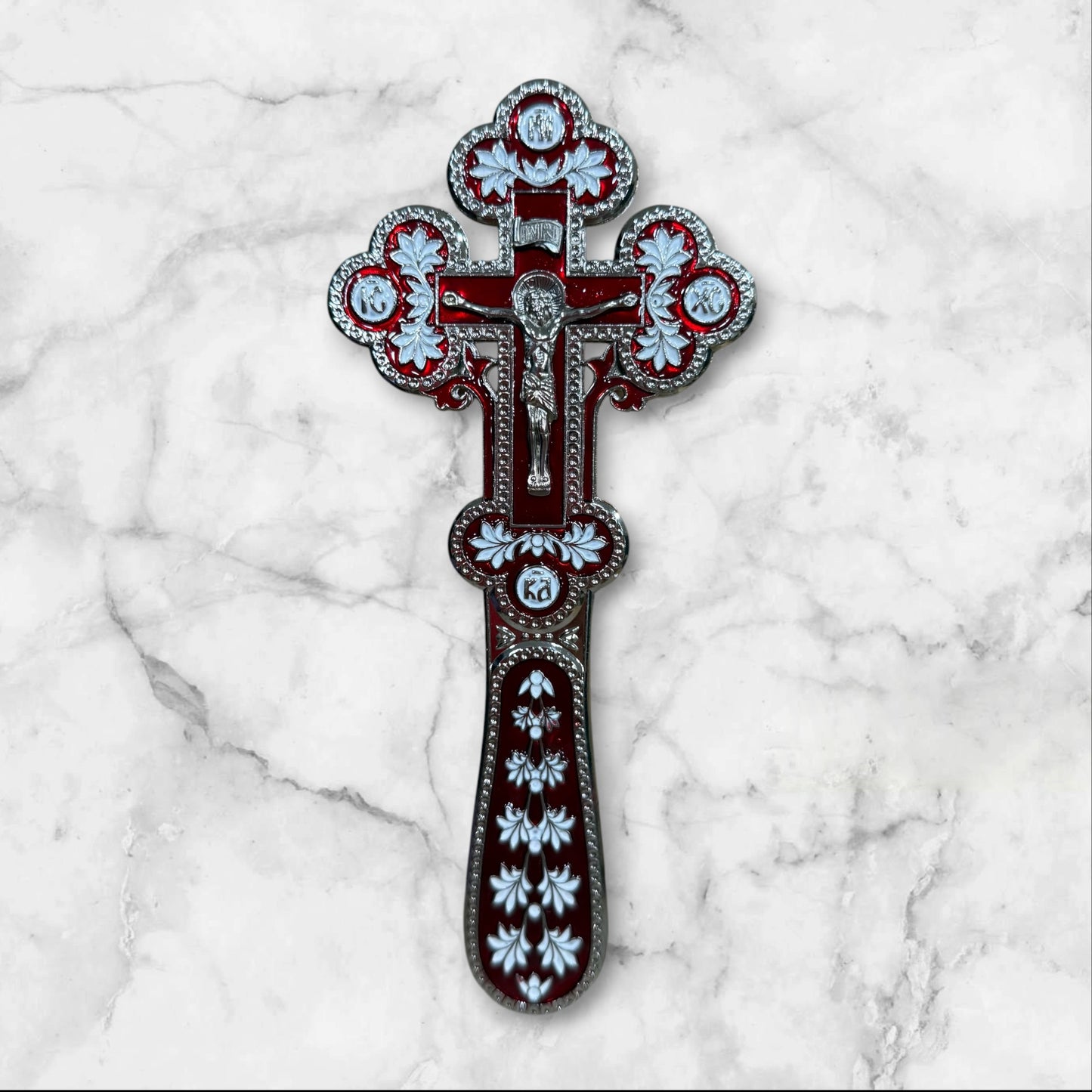 Double-sided red and white enamel blessing cross with metal crucifix displayed inside a premium gift box.