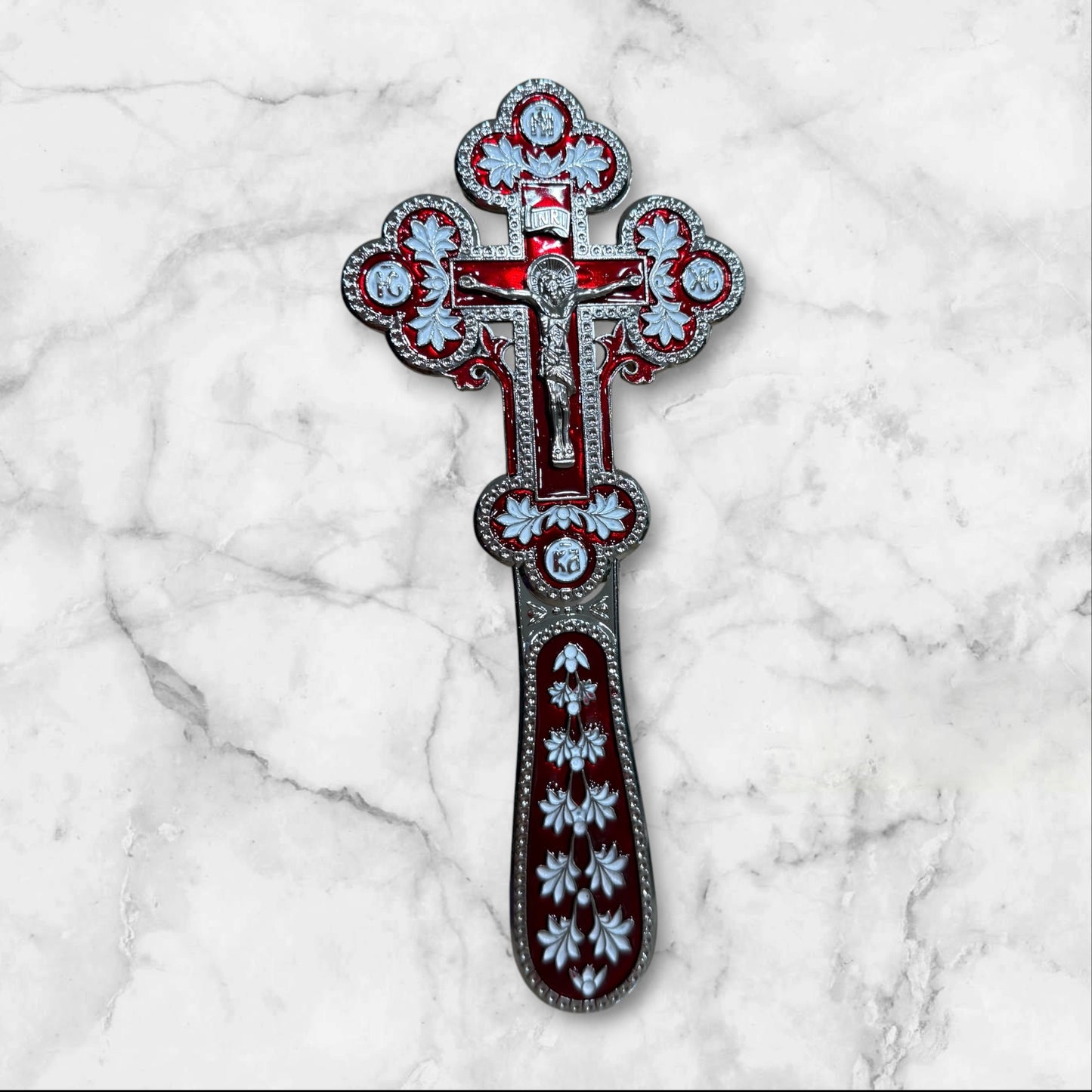 Double-sided red and white enamel blessing cross with metal crucifix displayed inside a premium gift box.