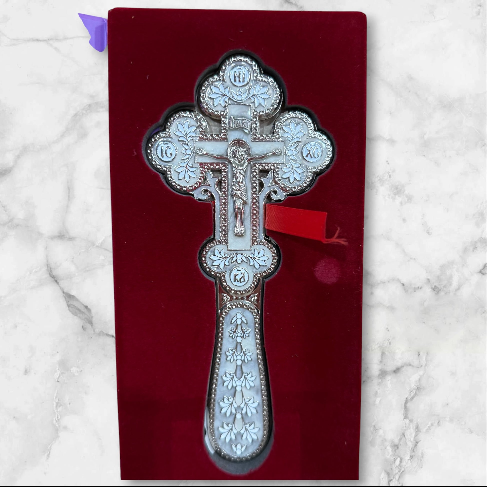 white enamel blessing cross with metal crucifix displayed inside a premium gift box.