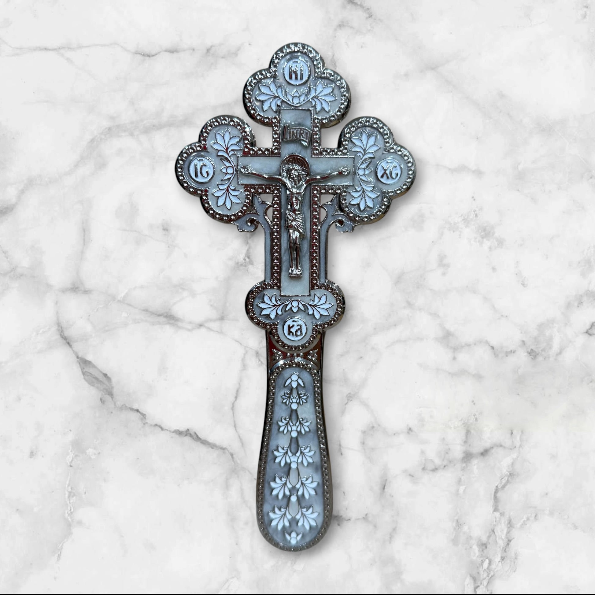 white enamel blessing cross with metal crucifix displayed inside a premium gift box.