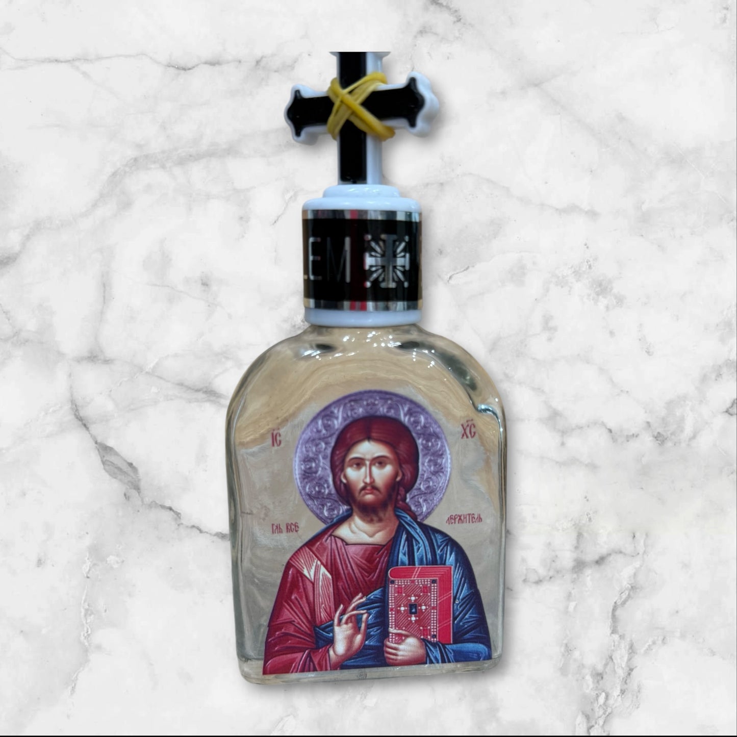 Orthodox holy water bottle featuring the icon of Christ the Teacher with decorative cross stopper