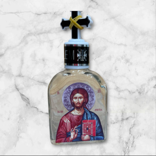 Orthodox holy water bottle featuring the icon of Christ the Teacher with decorative cross stopper