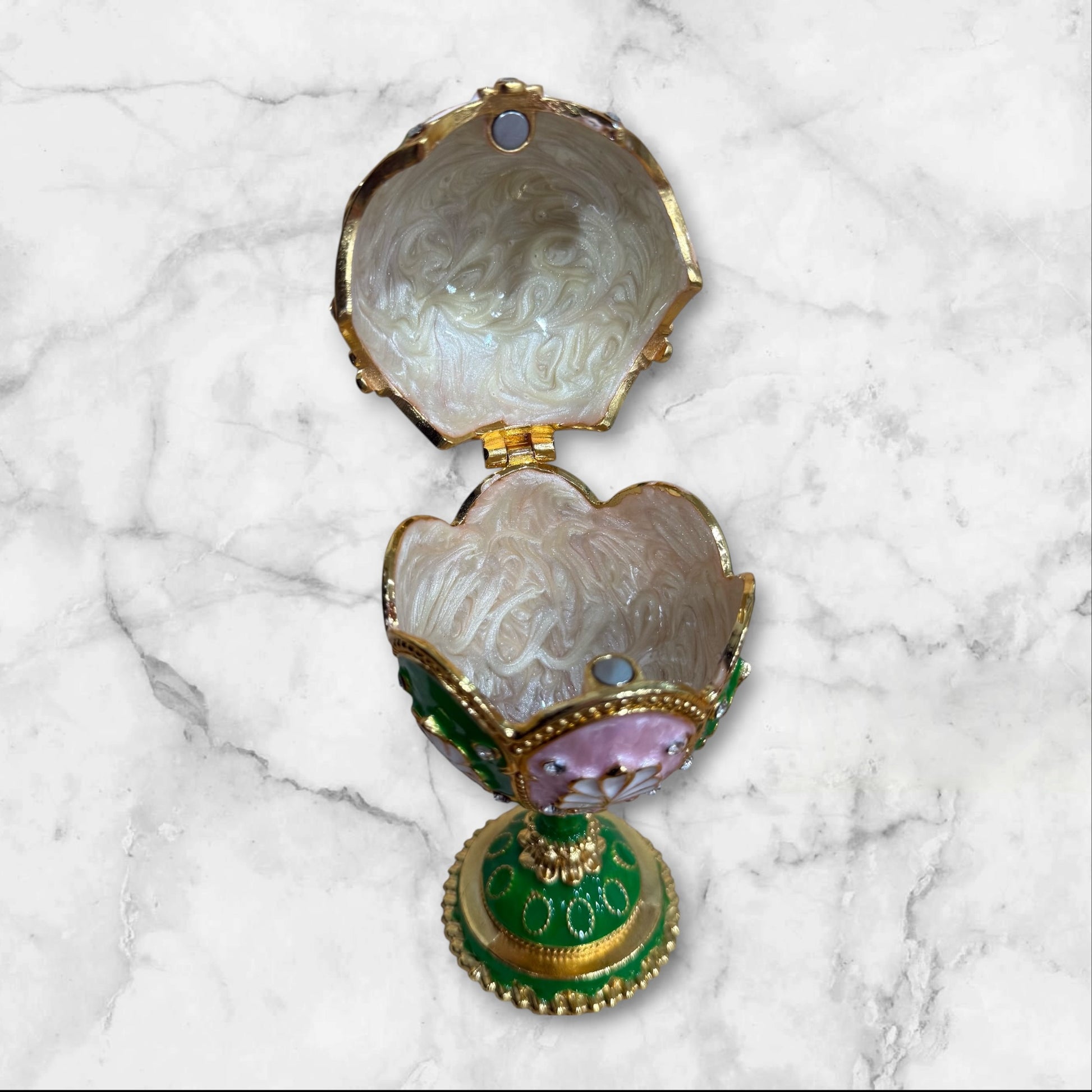 Open Fabergé-style jewelry box showing interior storage compartment