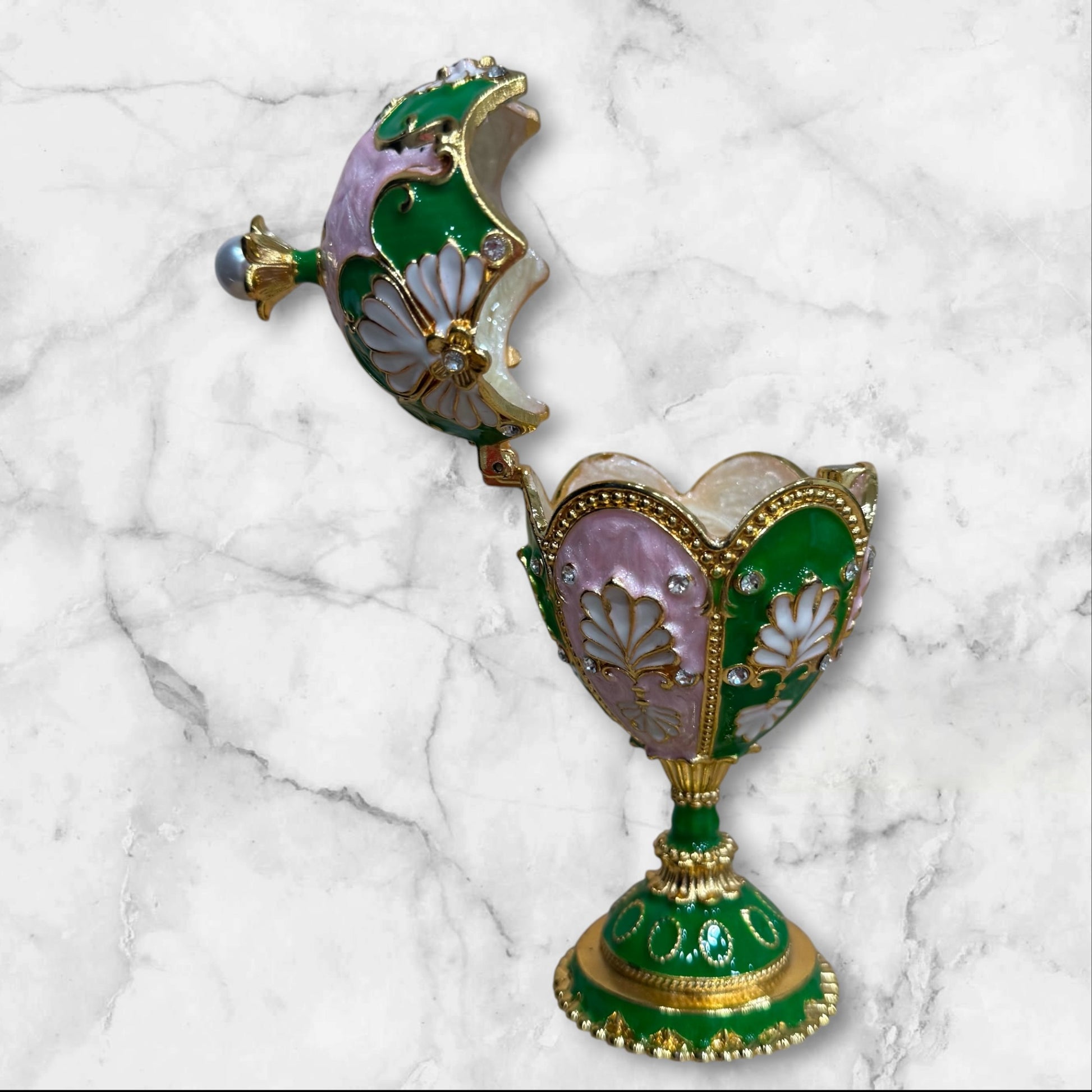 Green and pink Fabergé-style enamel jewelry box on decorative pedestal side view