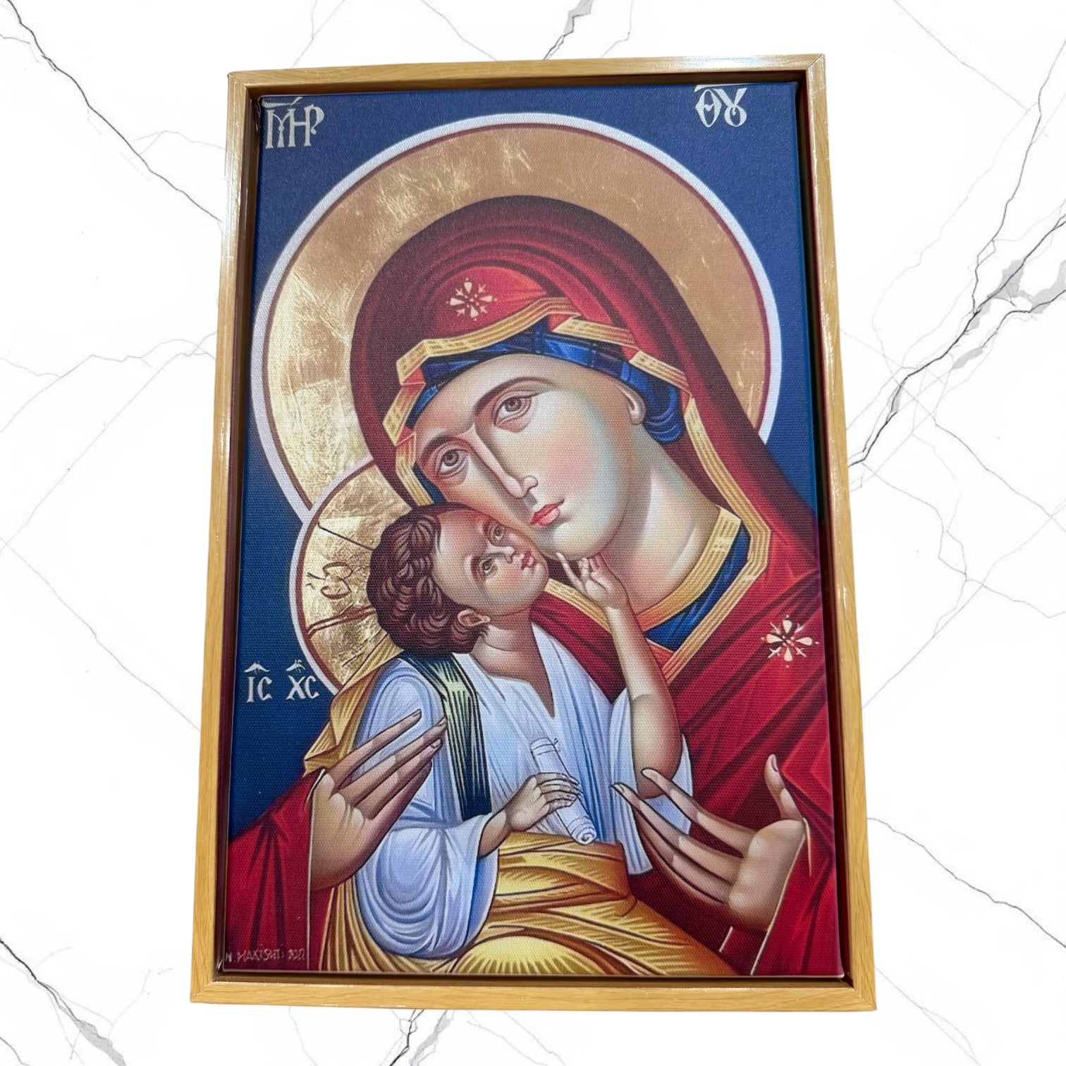 Framed Orthodox icon of the Most Holy Theotokos tenderly embracing the Christ Child.
