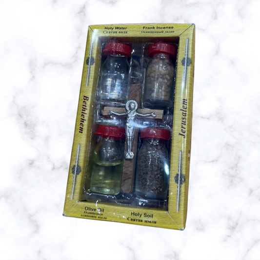 Back of Holy Land blessing gift set showing olive wood cross, holy water, olive oil, frankincense, and holy soil inside the gift box.