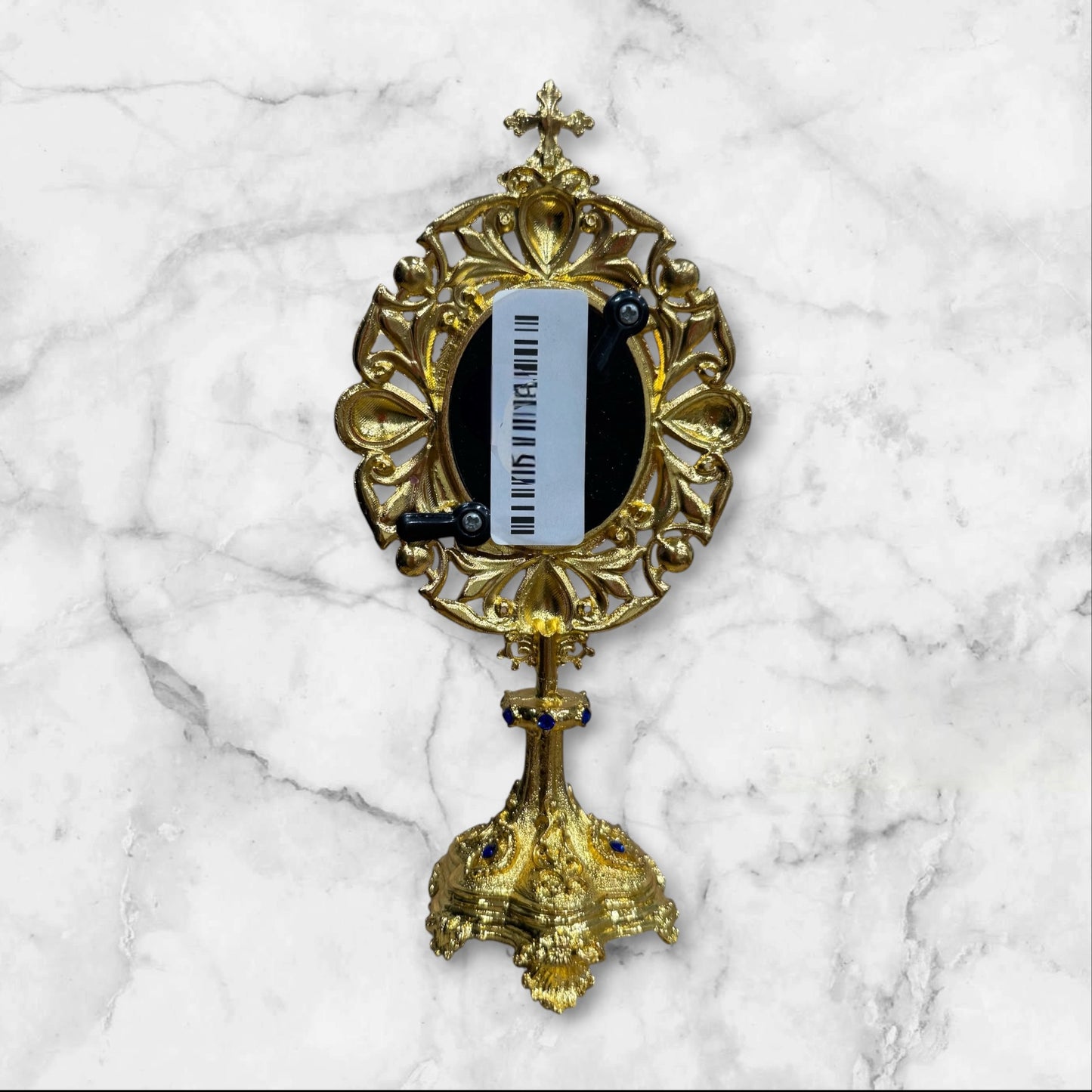 Jeweled oval standing icon of Saint Nicholas featuring an ornate gold-tone frame with blue enamel accents, pearl details, rhinestones, and a decorative freestanding base.