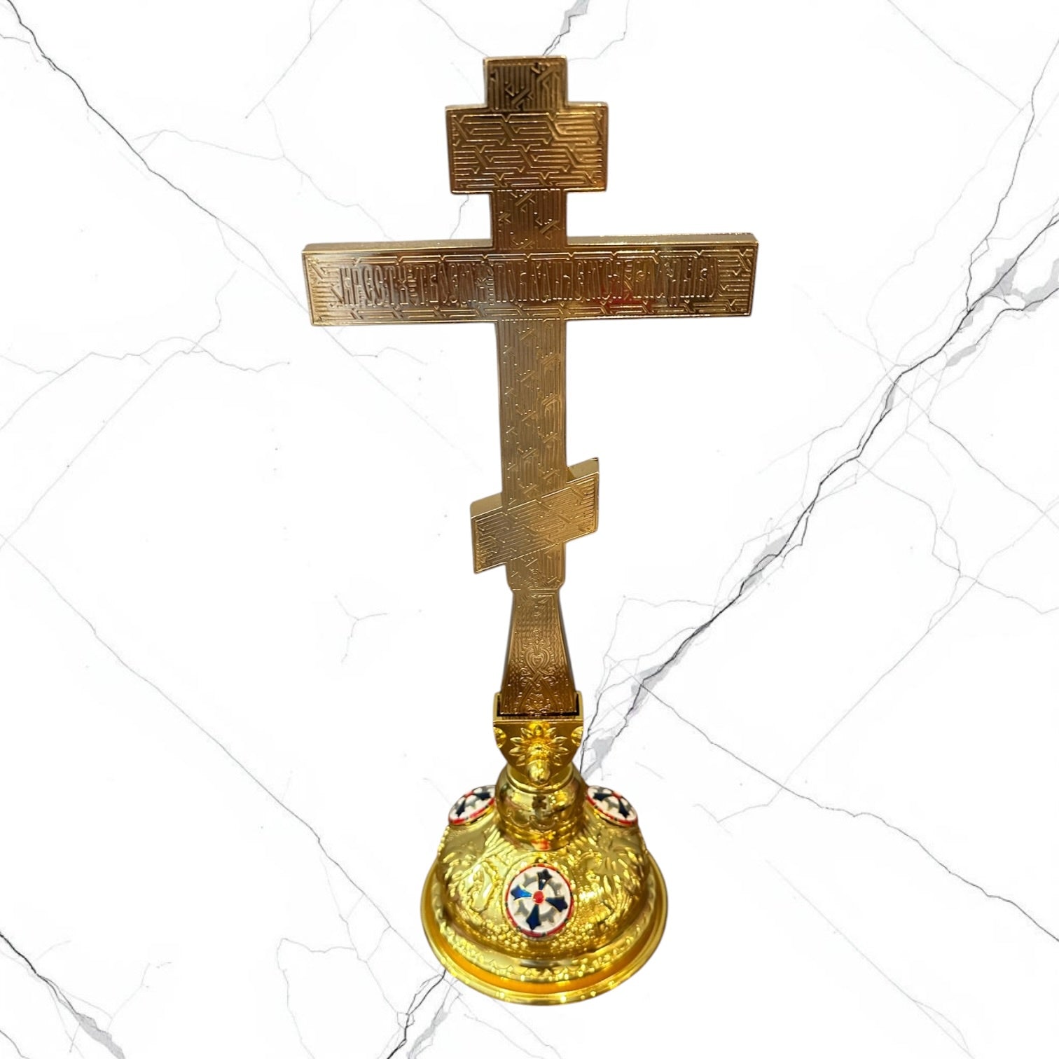 White enamel Orthodox standing blessing cross with ornate gold-tone base.