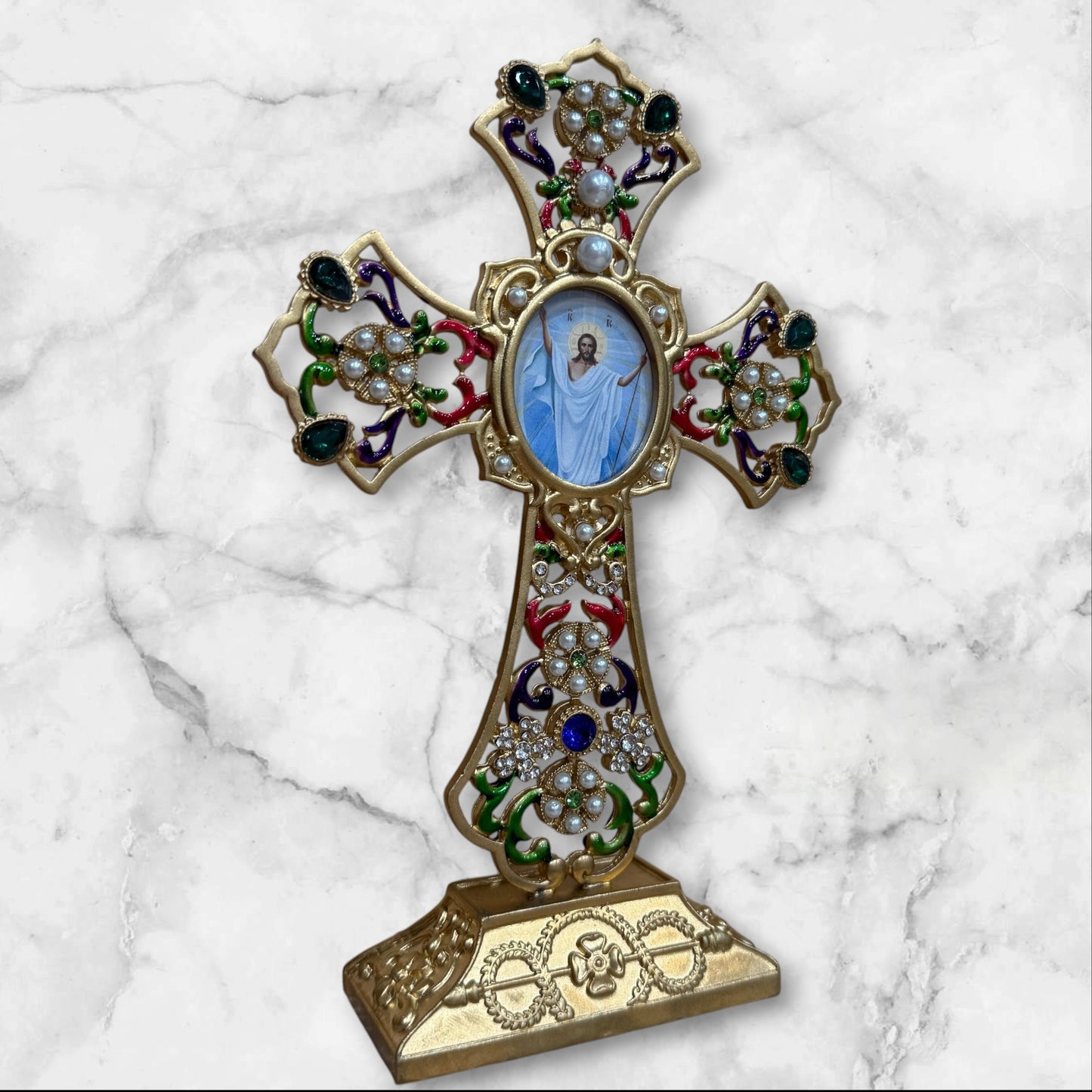Decorative Orthodox cross-shaped icon stand with colorful enamel accents and a removable oval icon for a home prayer corner angled front view