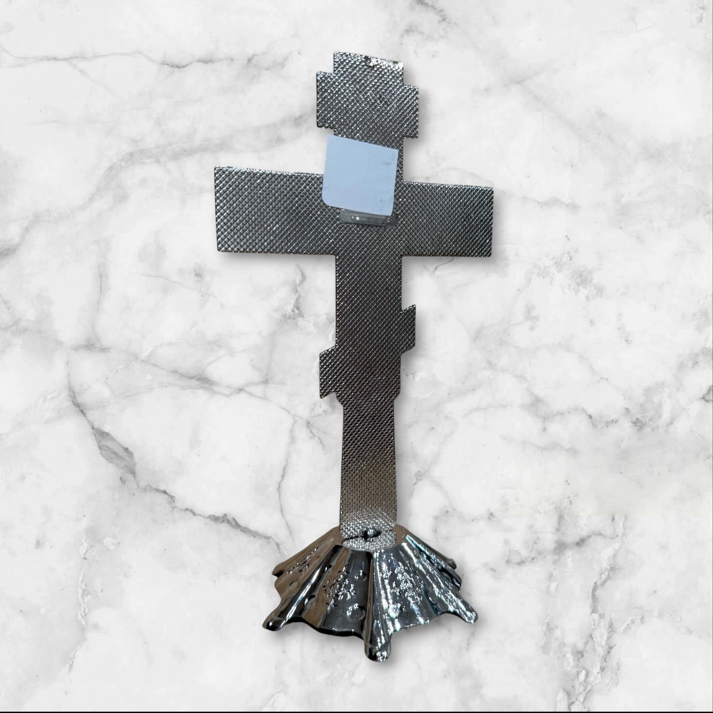Silver Orthodox standing crucifix with icon accents on a decorative freestanding base for a home prayer corner