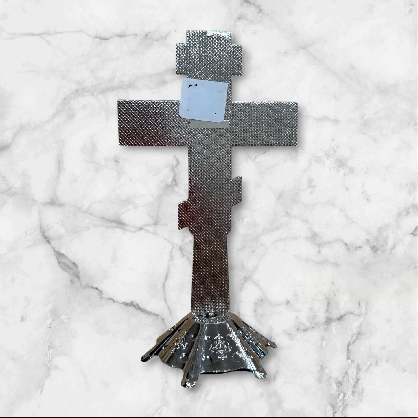 Silver Orthodox standing crucifix with icon accents on a decorative freestanding base for a home prayer corner