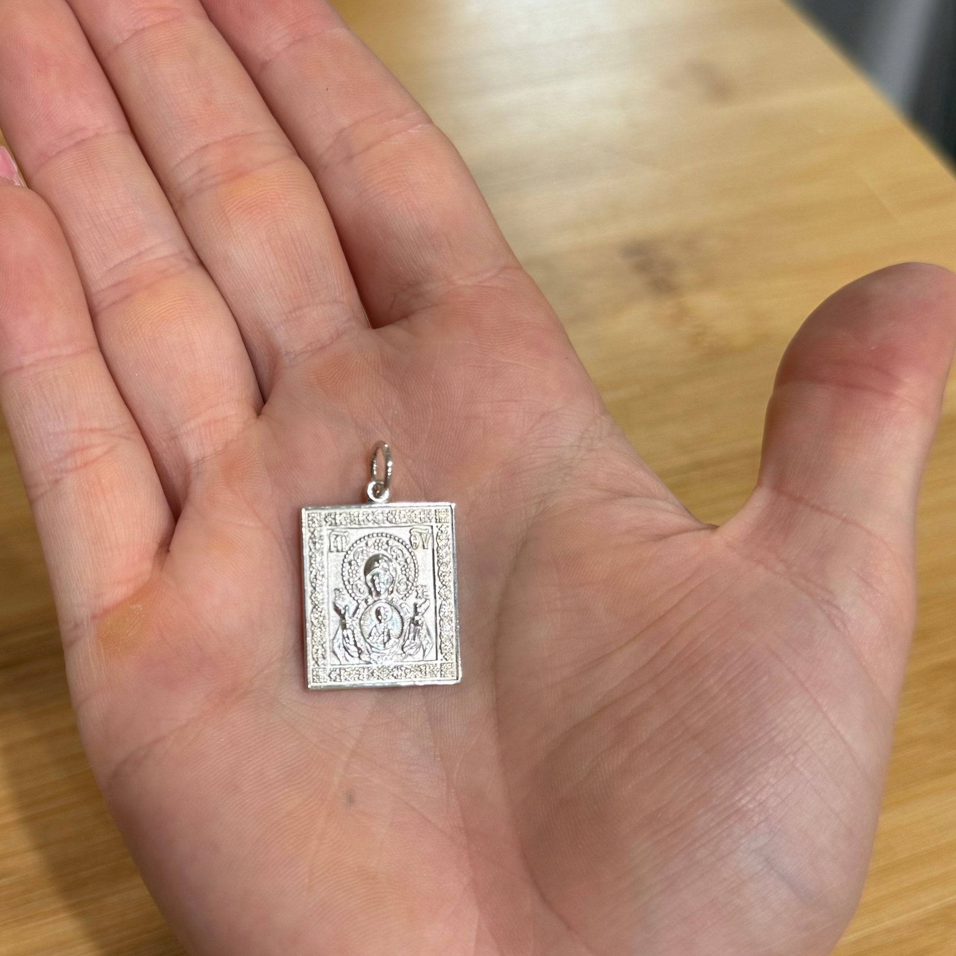 Saint Matrona icon pendant shown in hand to illustrate approximate size.