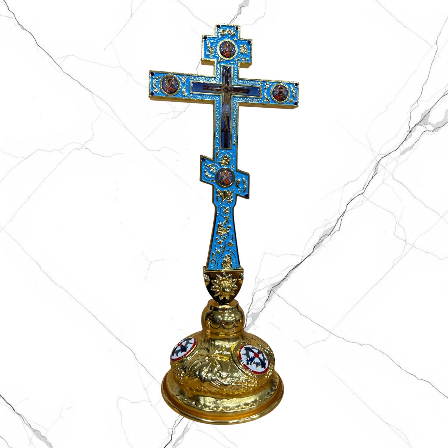 Ornate Orthodox standing blessing cross in blue and gold with sacred icon medallions, jeweled accents, Crucifixion detail, and decorative base.