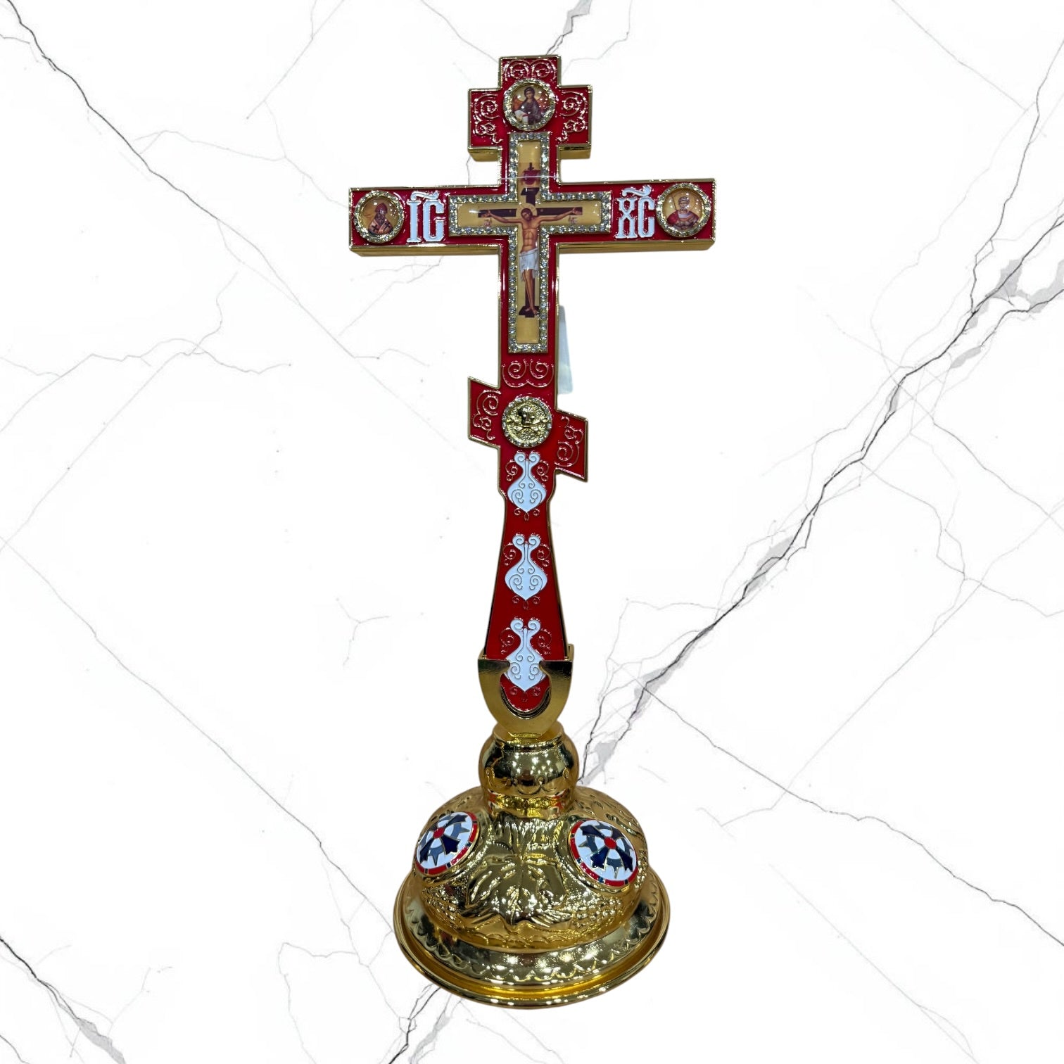 Orthodox standing blessing cross with red enamel accents, central crucifix, icon medallions, and decorative gold-tone base.