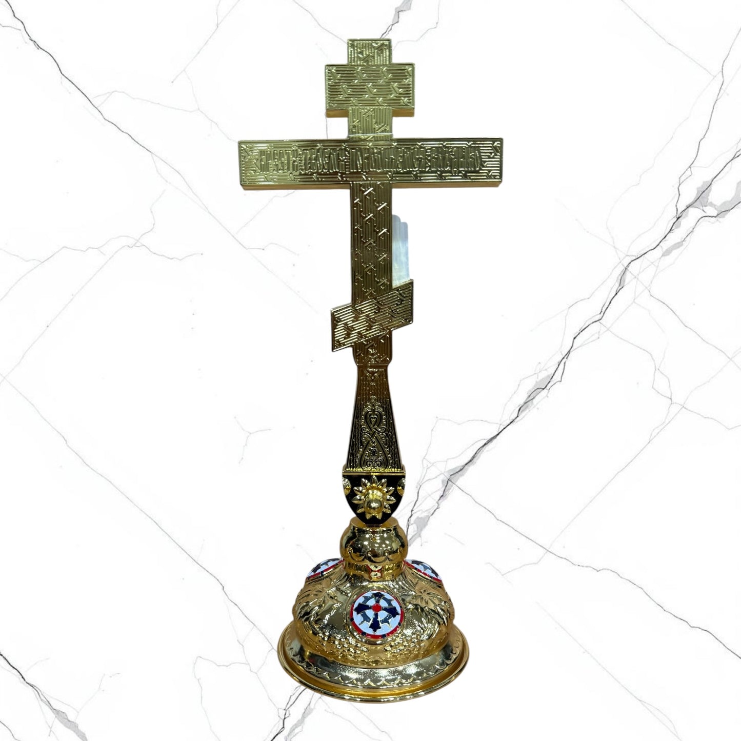 Orthodox standing blessing cross with red enamel accents, central crucifix, icon medallions, and decorative gold-tone base.