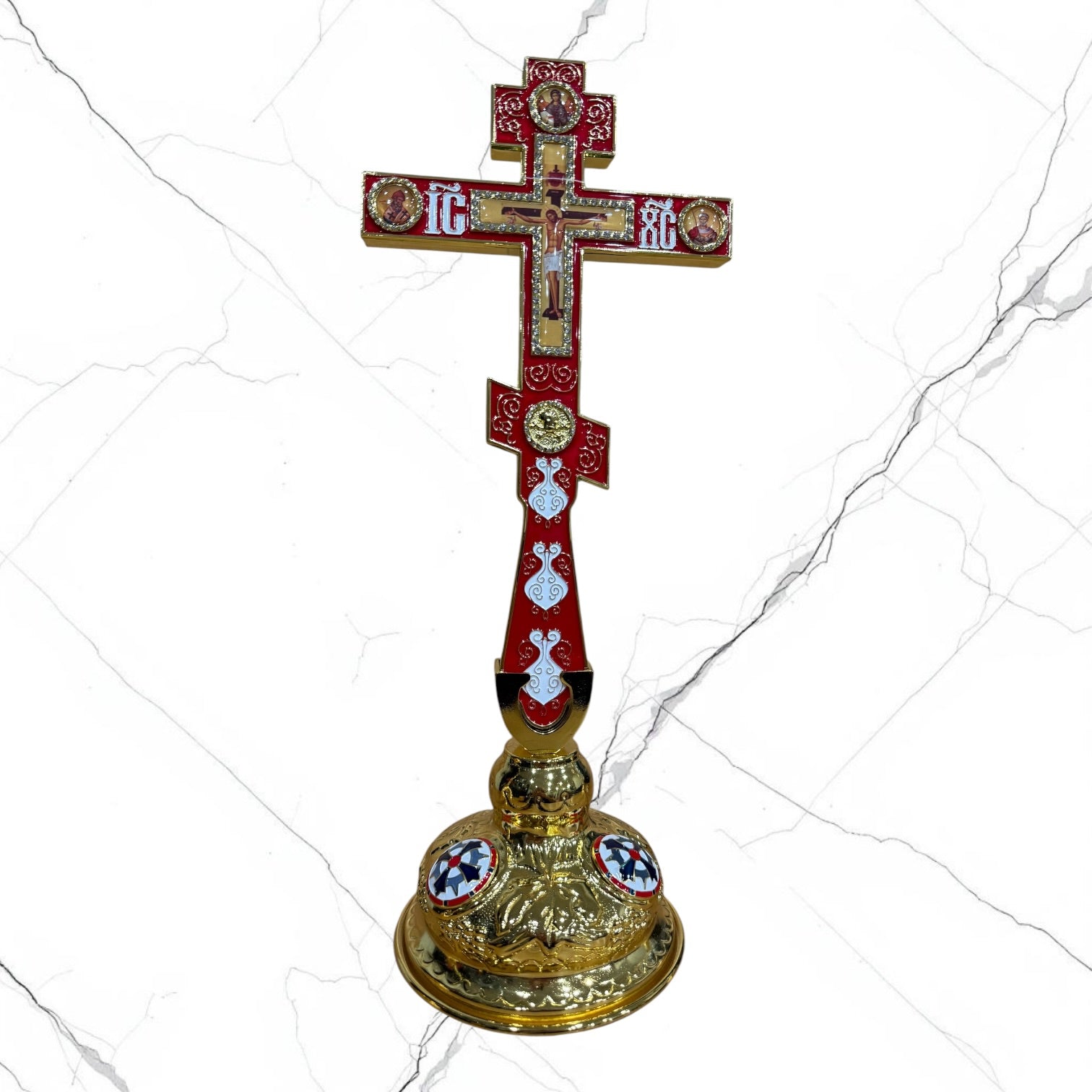 Orthodox standing blessing cross with red enamel accents, central crucifix, icon medallions, and decorative gold-tone base.