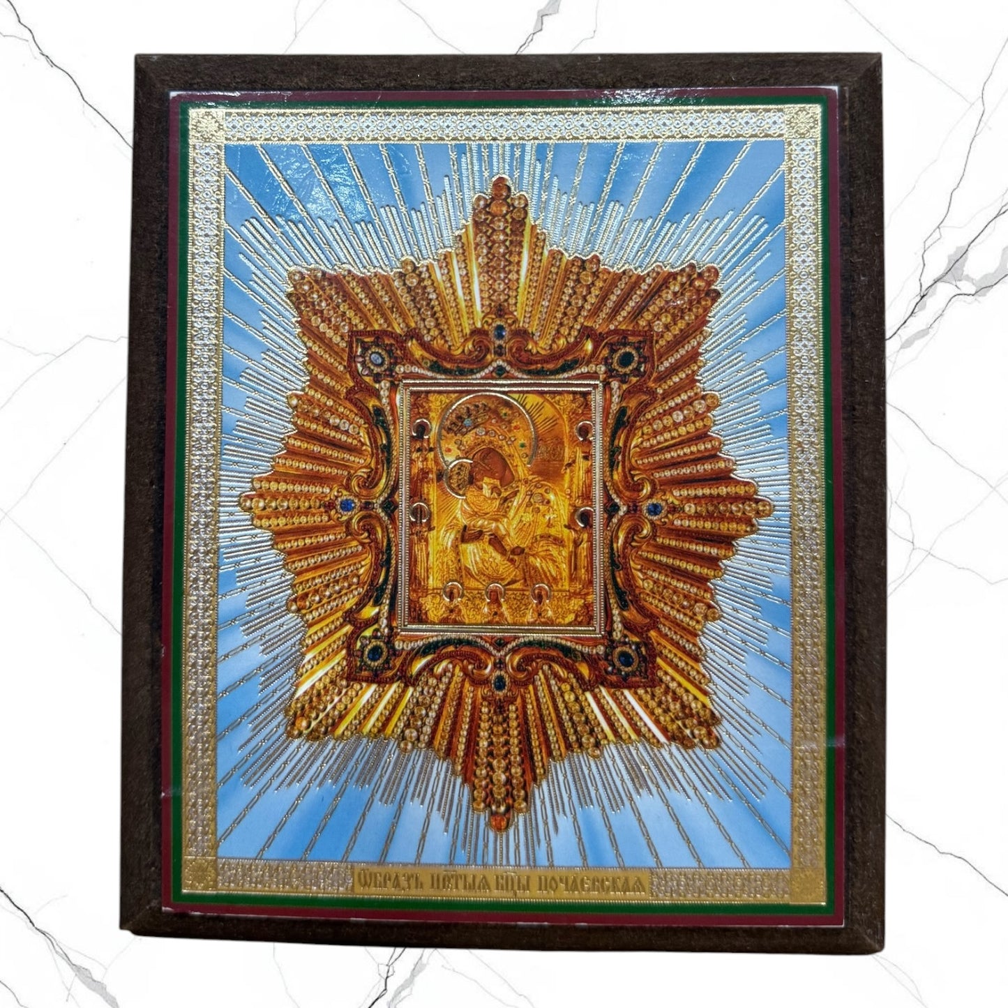 Wood icon of the Pochaev Mother of God with decorative metallic embellishments.